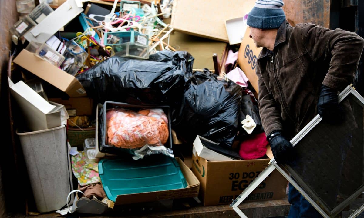 A man standing in front of a pile of garbage